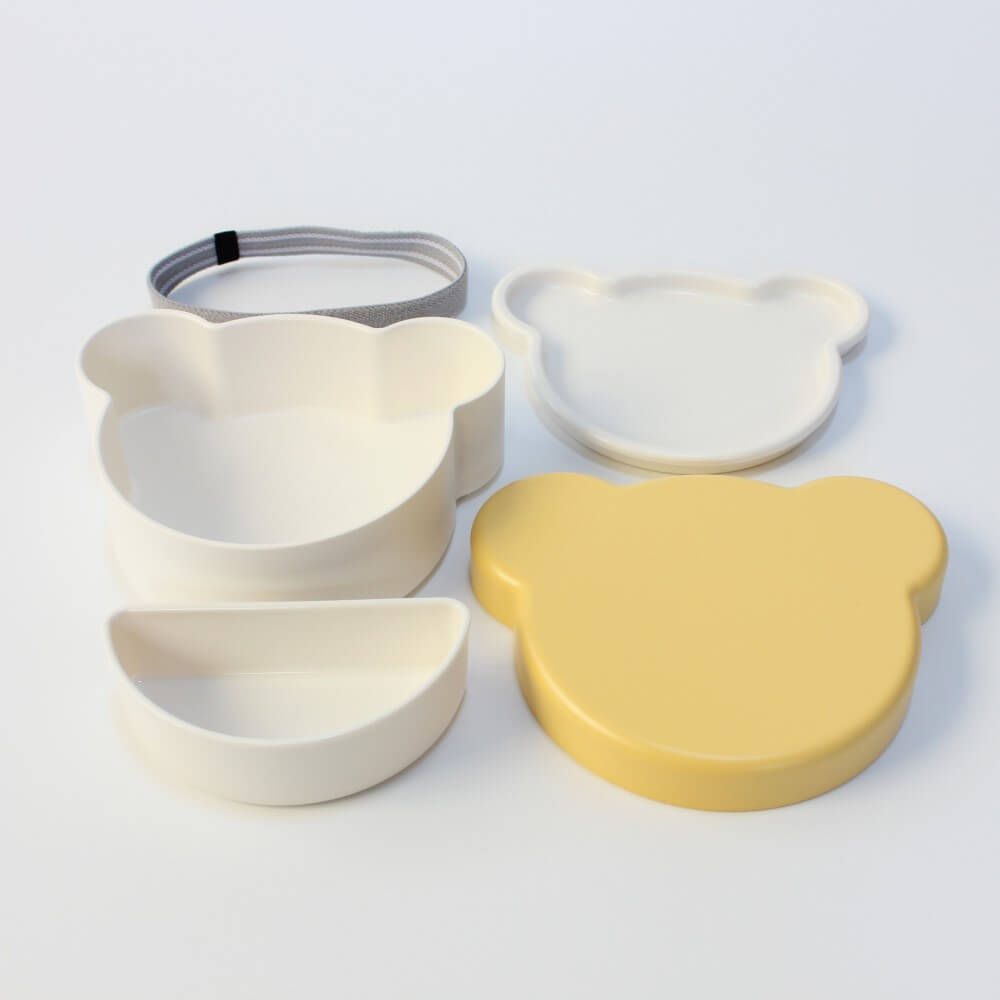 all components of yellow kids dish lunch box from takenaka, laid out