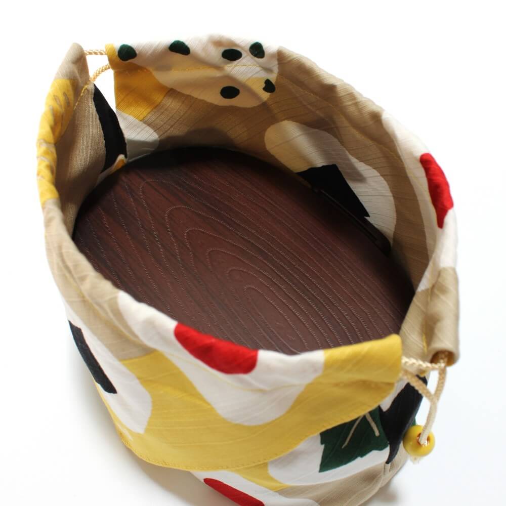 brown bento box seen inside the onigiri tsutsumi bento lunch bag