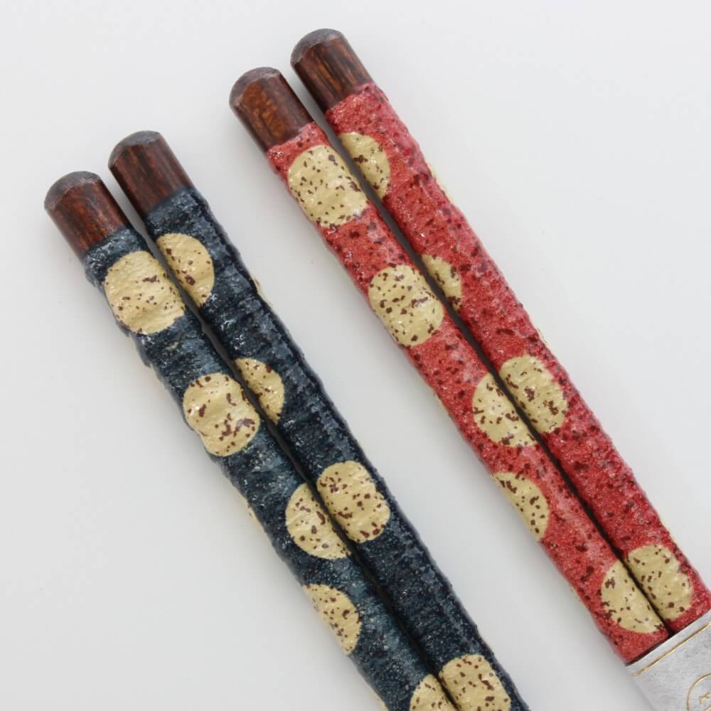 closeup handles blue red chopsticks showing polka dots and rough surface