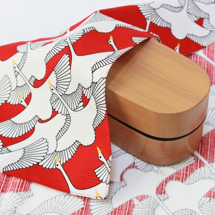 celebration crane red furoshiki covering a light brown bento box