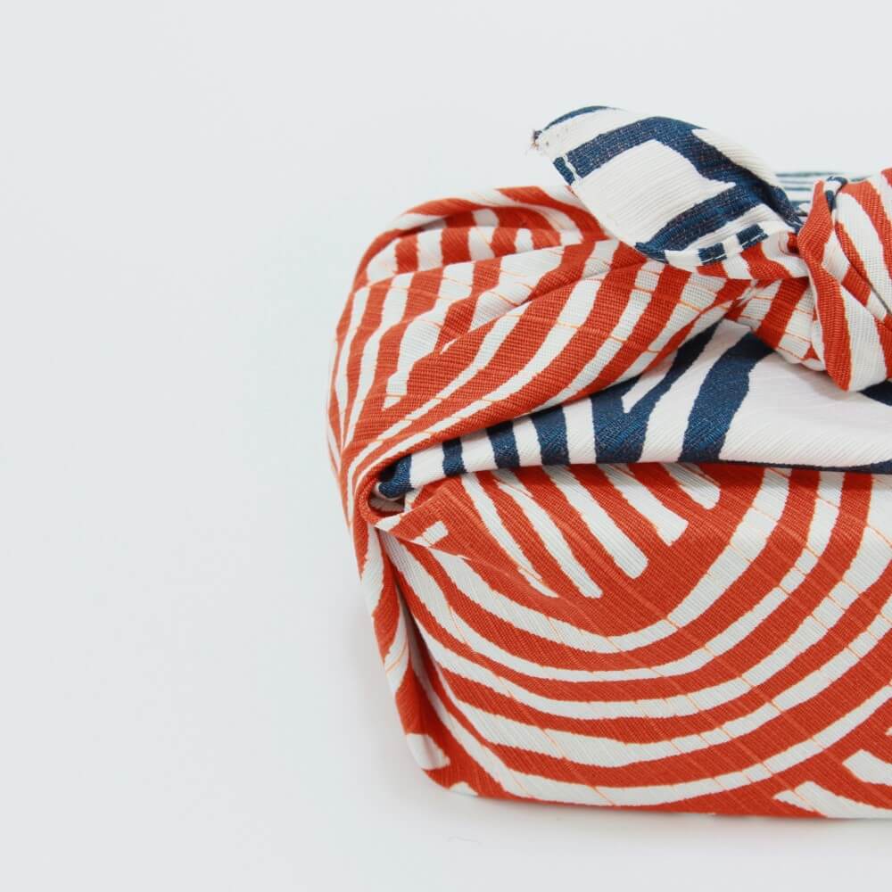 close up bento box wrapped knot blue orange furoshiki