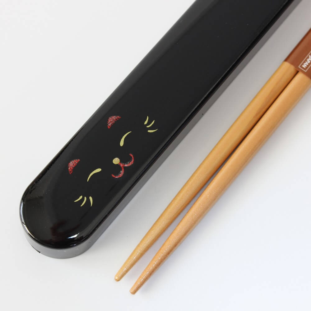 close up cat face maneki cat black chopsticks case and tips closeup