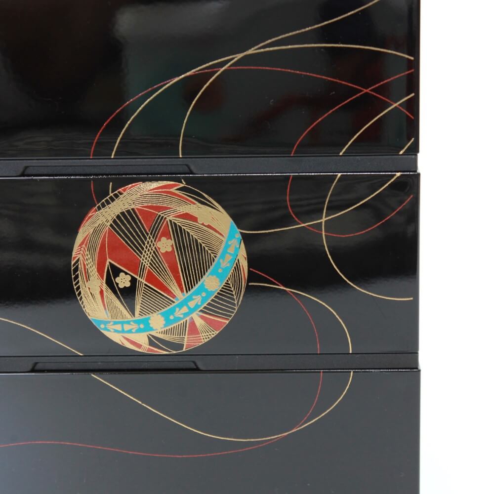 close up gold temari ball side of jubako bento box