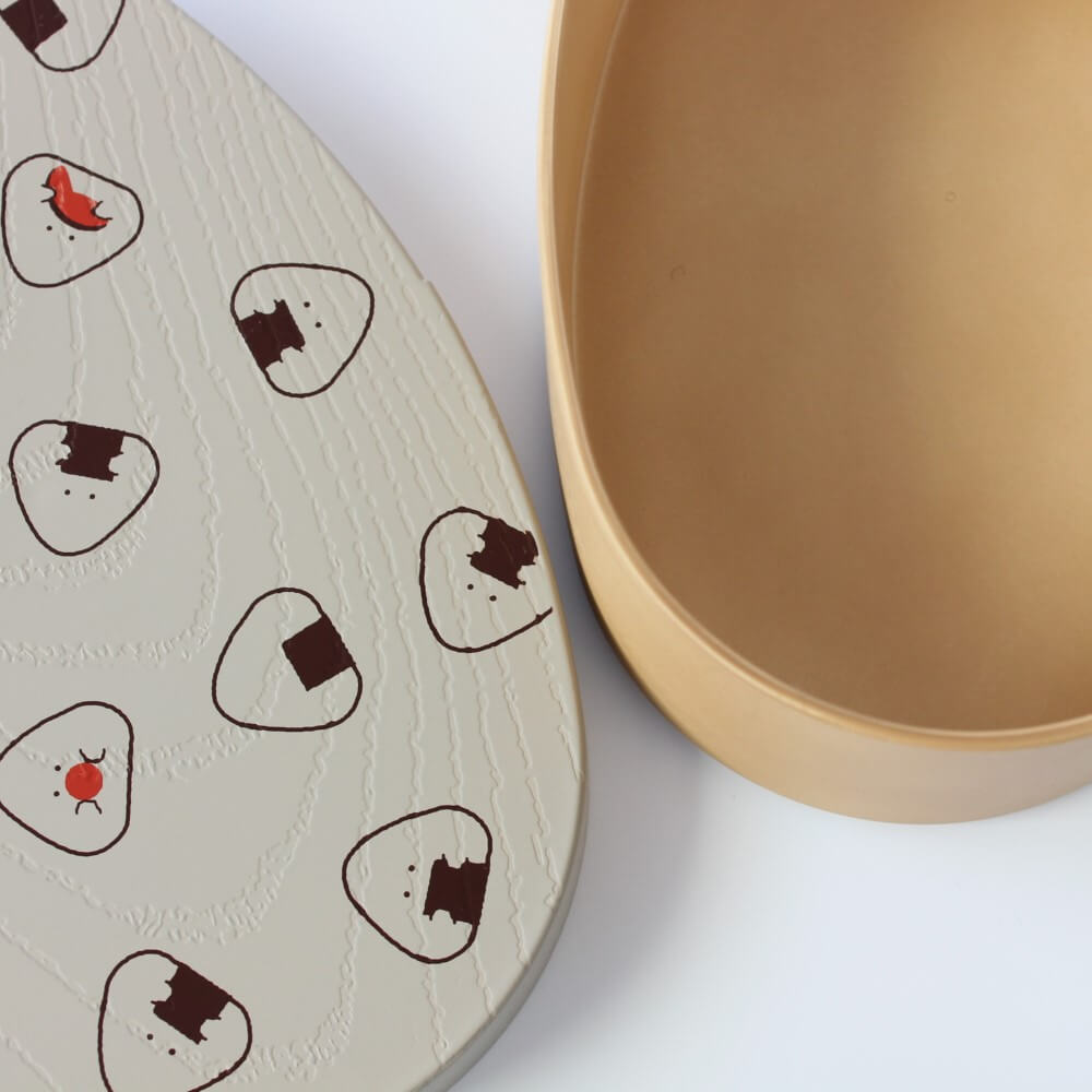 close up grey onigiri lid next to box box compartment
