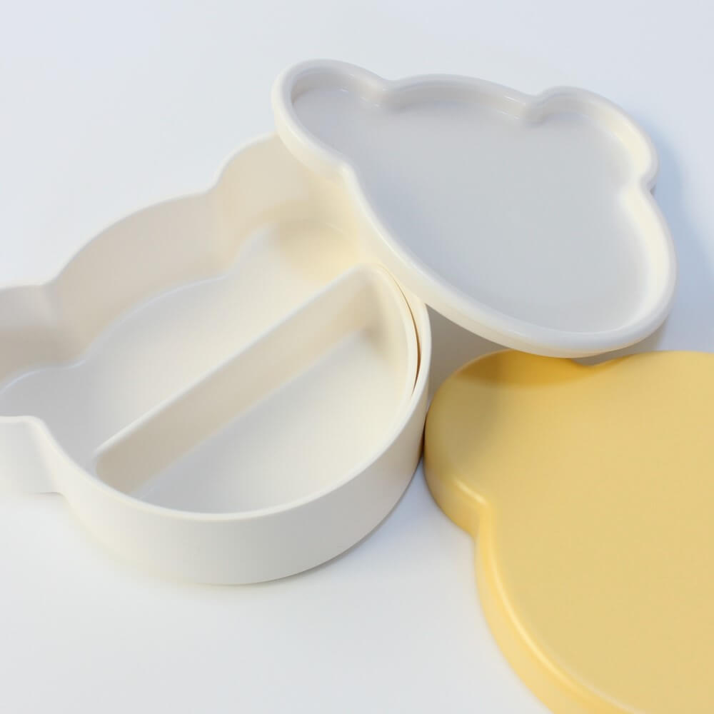 close up of the inside of the yellow bear shaped bento box from takenaka, showing the internal partition