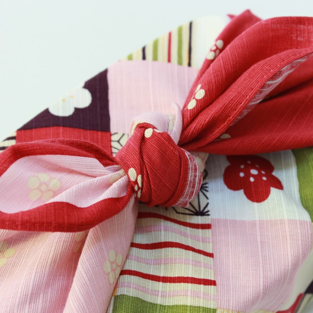 close up of knot tied colourful ichimatsu furoshiki