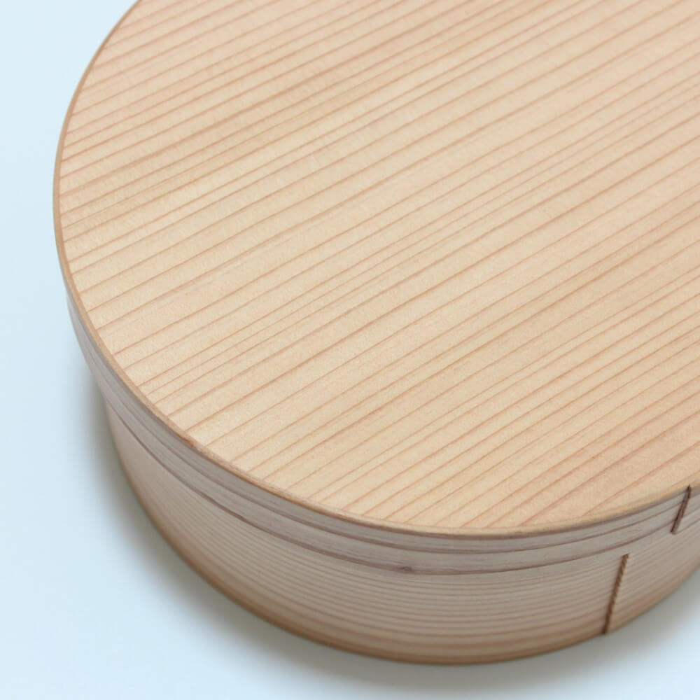 close up of lid of round magewappa bento box showing wood grain texture