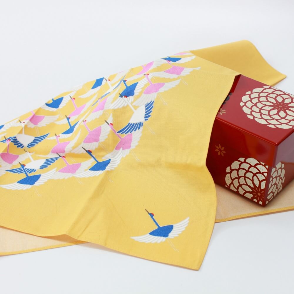 crane yellow furoshiki covering a red bento box