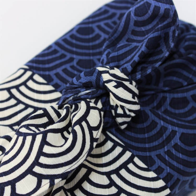 close up shot of knot showing blue wave patterns of furoshiki