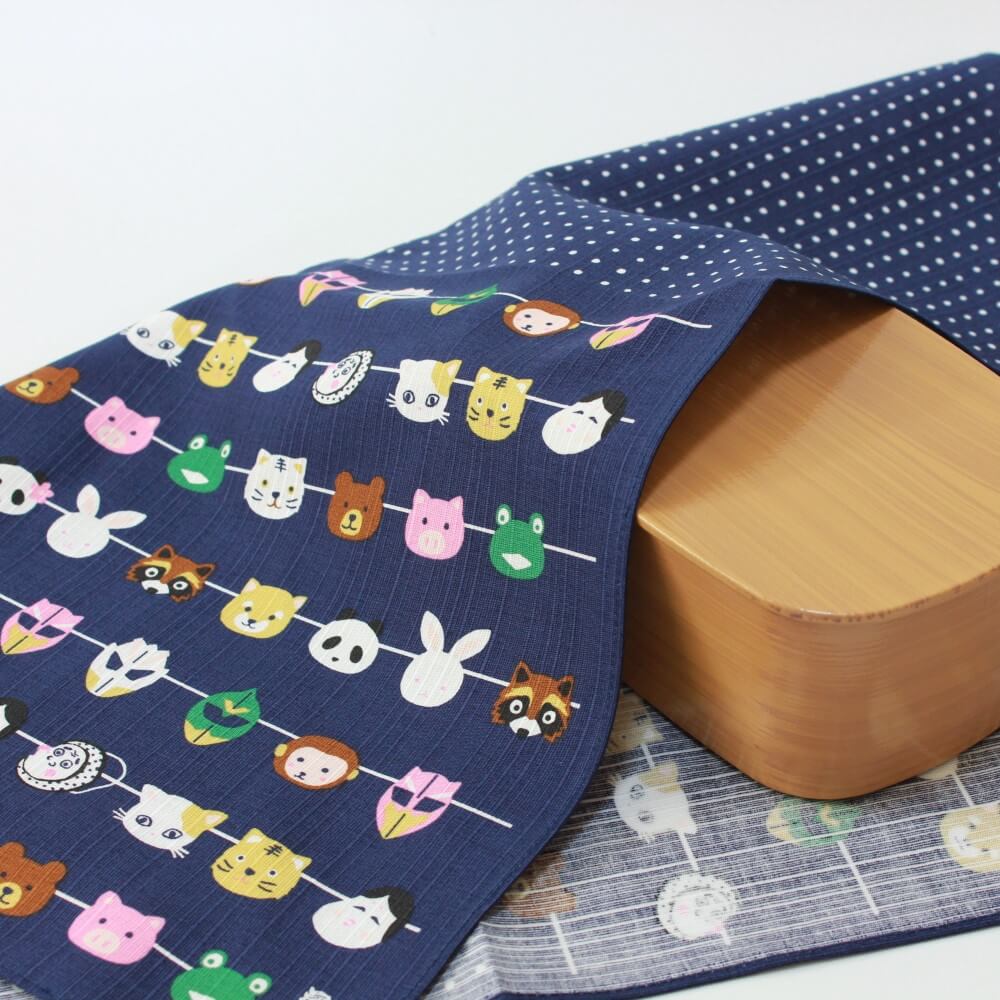 japanese masks furoshiki covering a brown bento box