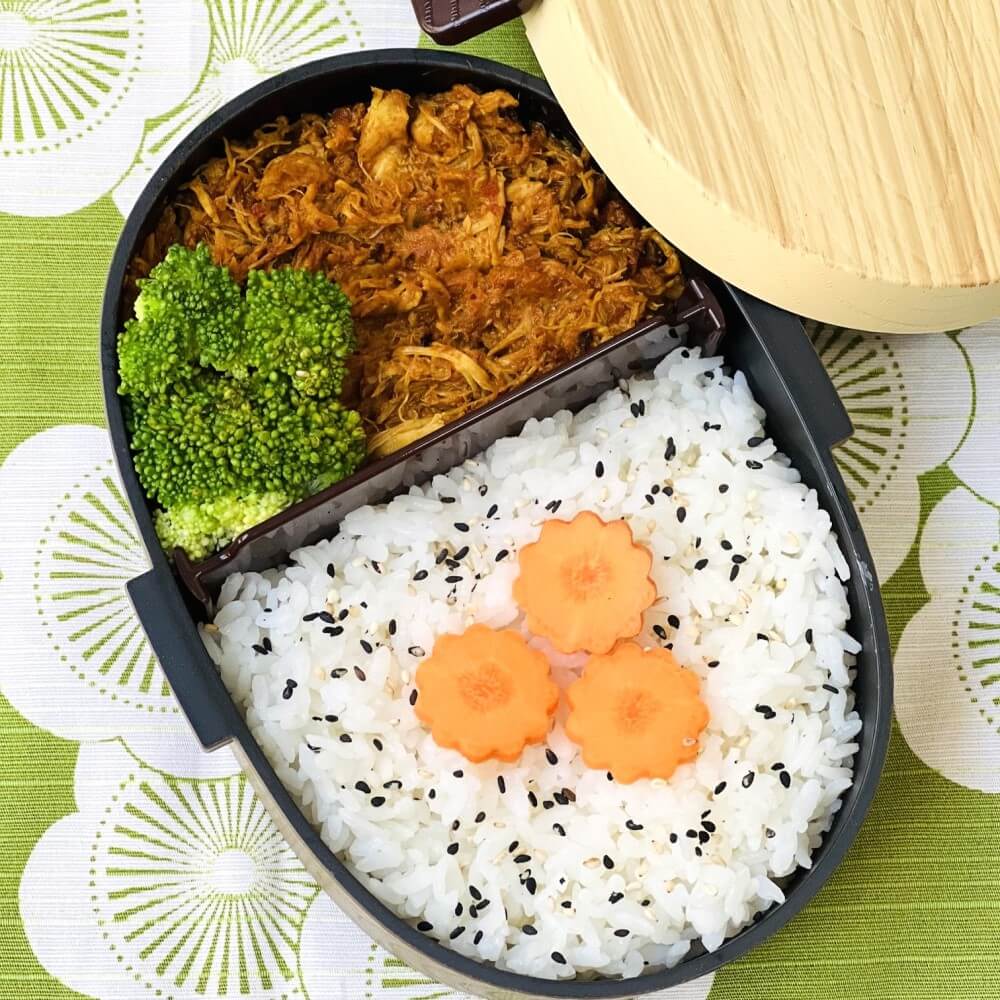 overhead photo showing curry bento in hinoki brown bento box