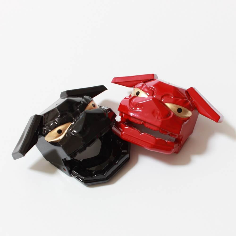 red shishimai chopsticks rest on top of black rest