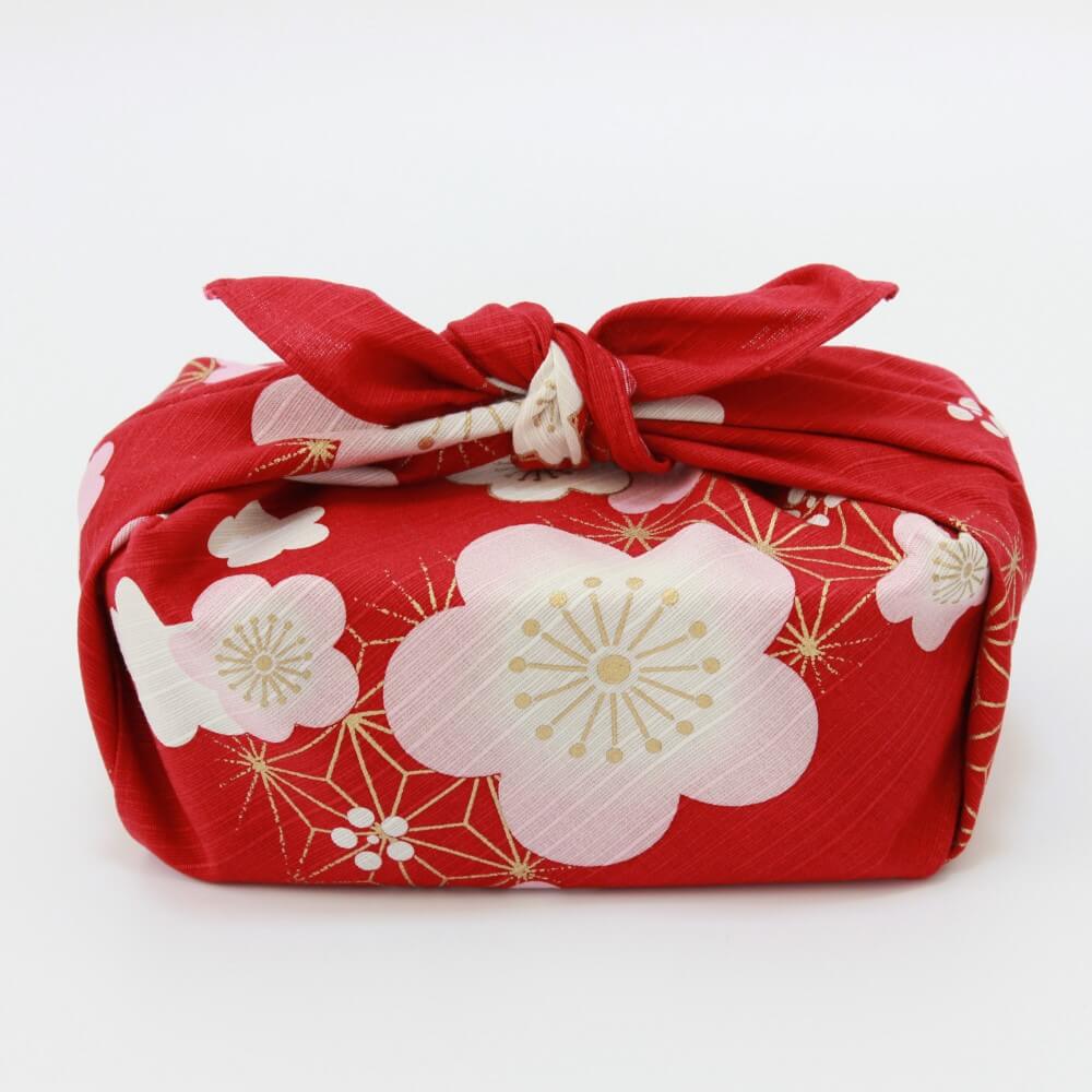side shot bento box wrapped in plum red furoshiki