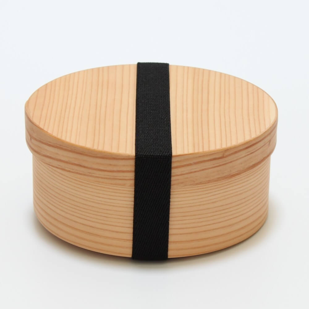 side view of round magewappa bento box secured with black bento band