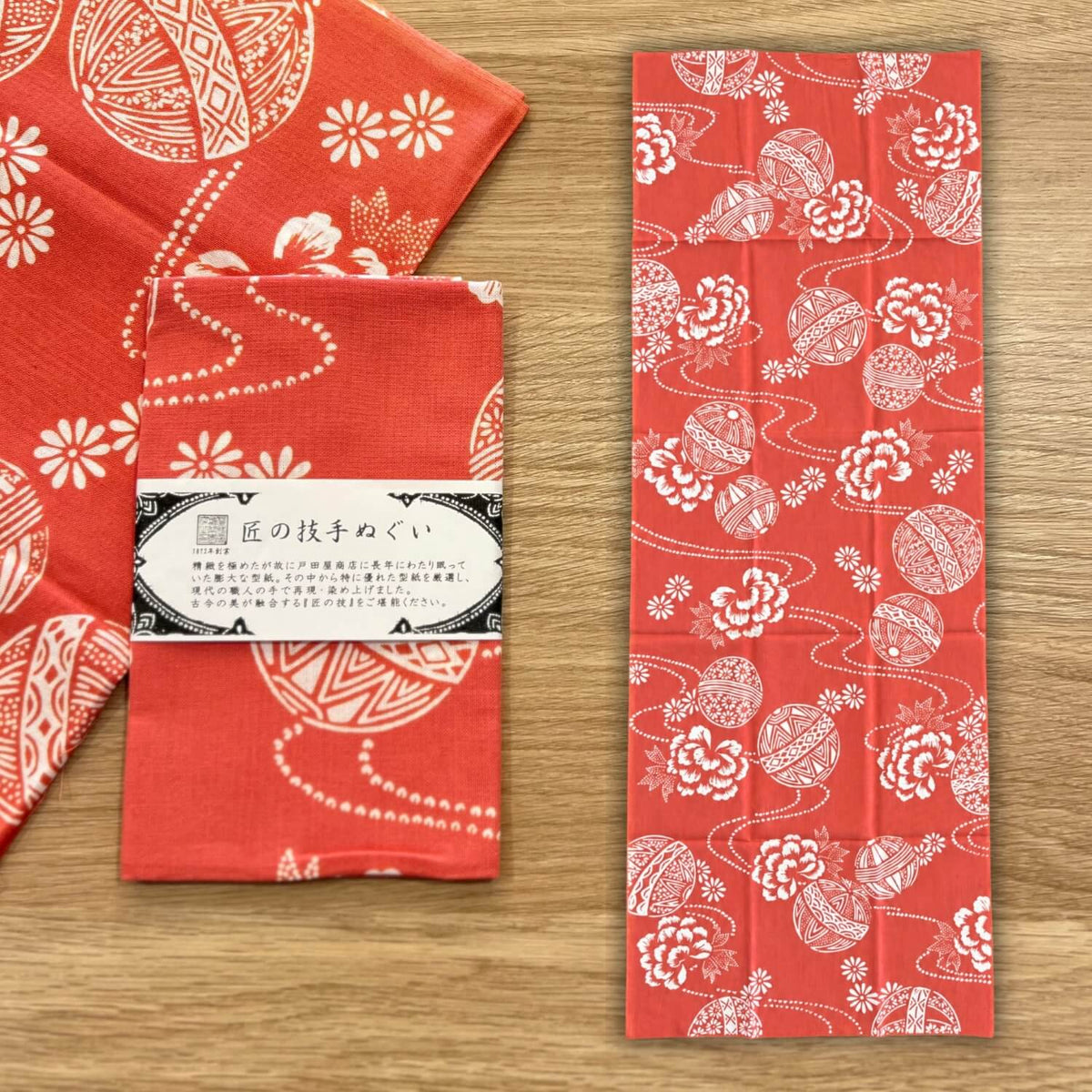 rienzome tenugui with temari balls and flower patterns on a bright red background