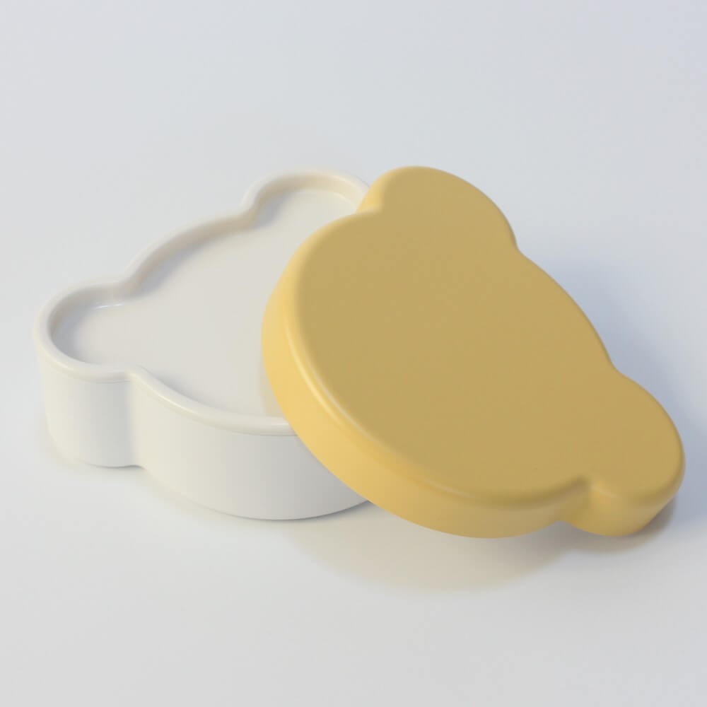 lid of yellow bear bento box from takenaka leaning on the base bento box