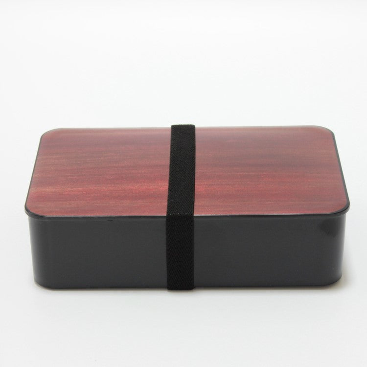 Side view of rosewood woodgrain bento box with black elastic band securing teh bento box.