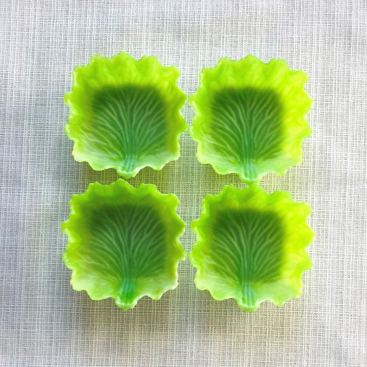 Four square green lettuce divider cups laid out