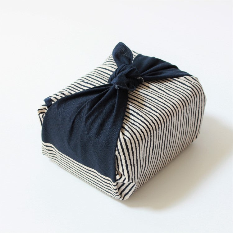 top angled view of a bento lunch box wrapped by the hama monyo shima furoshiki