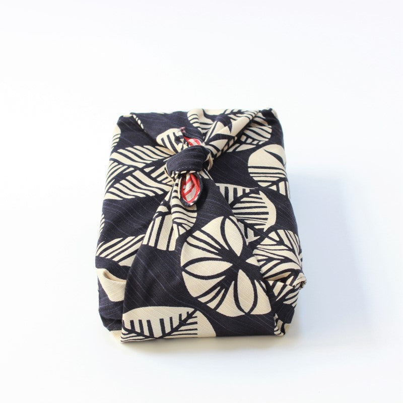Front view of isa monyo furoshiki showing the pine pattern on a navy blue backdrop, wrapped around a bento box