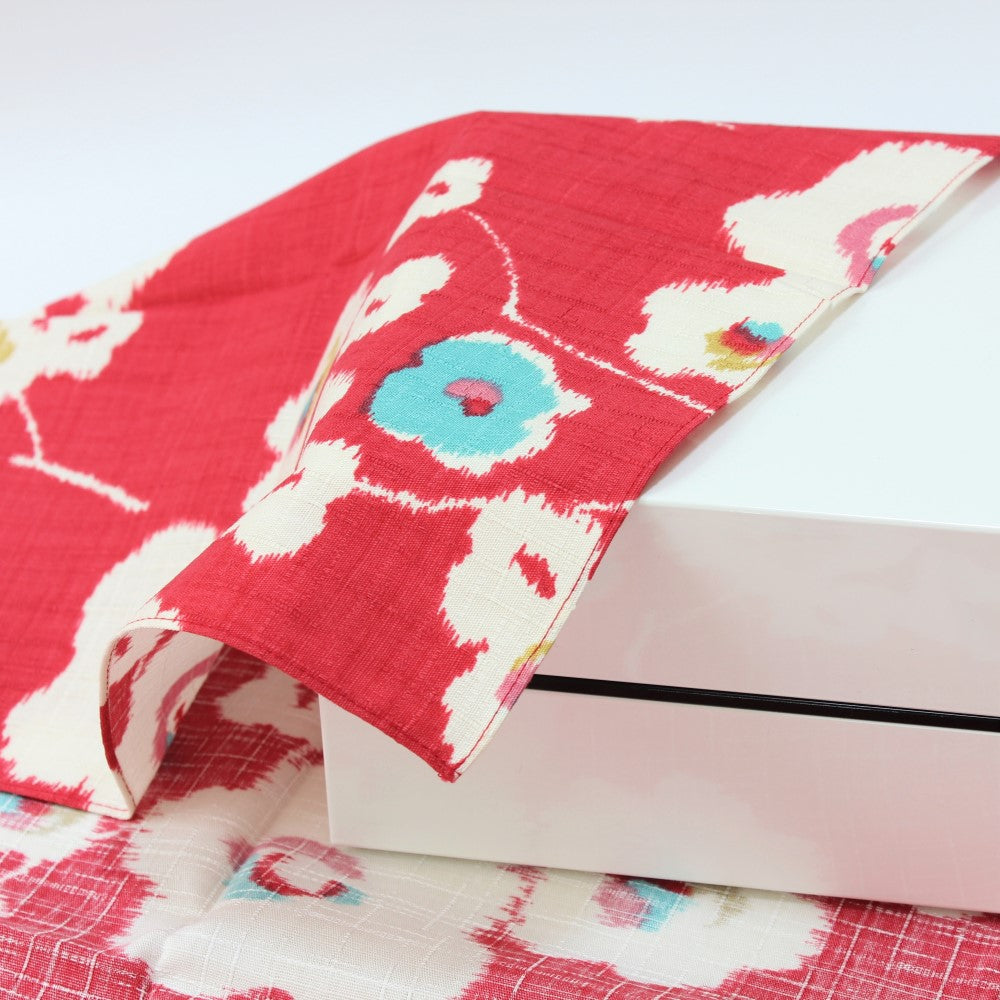 Floral pattern showing japanese plum flowers on a red background, over a picnic bento box from Majime Life