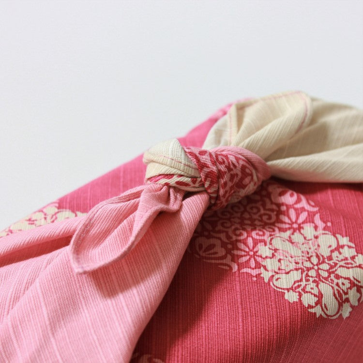 close up view of the knot that is tying a furoshiki over a bento box