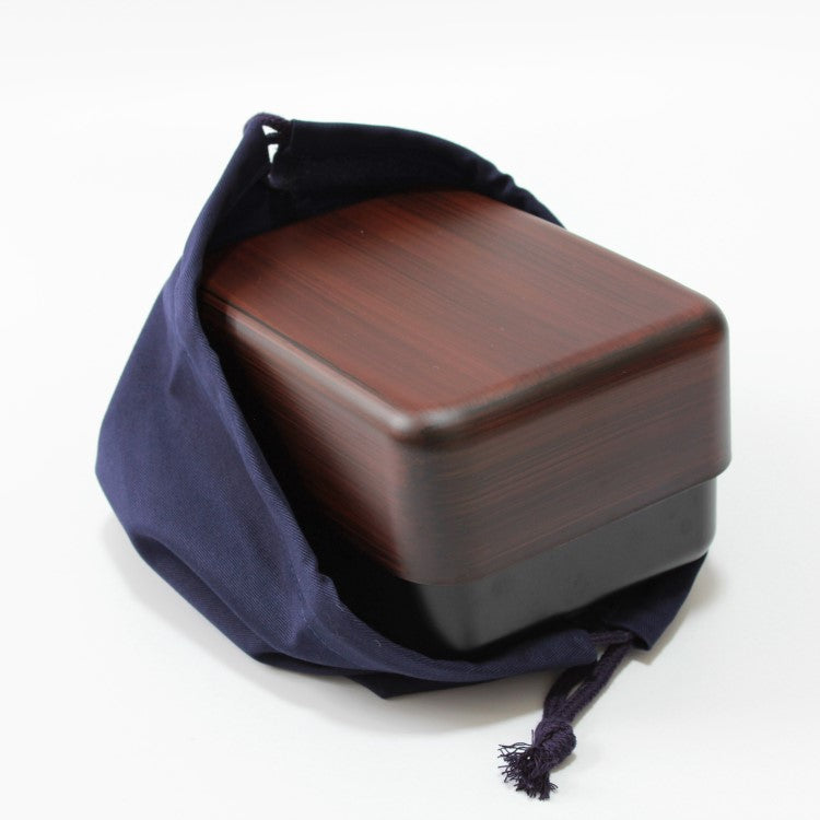 Bento box is sitting inside navy blue bento lunch bag