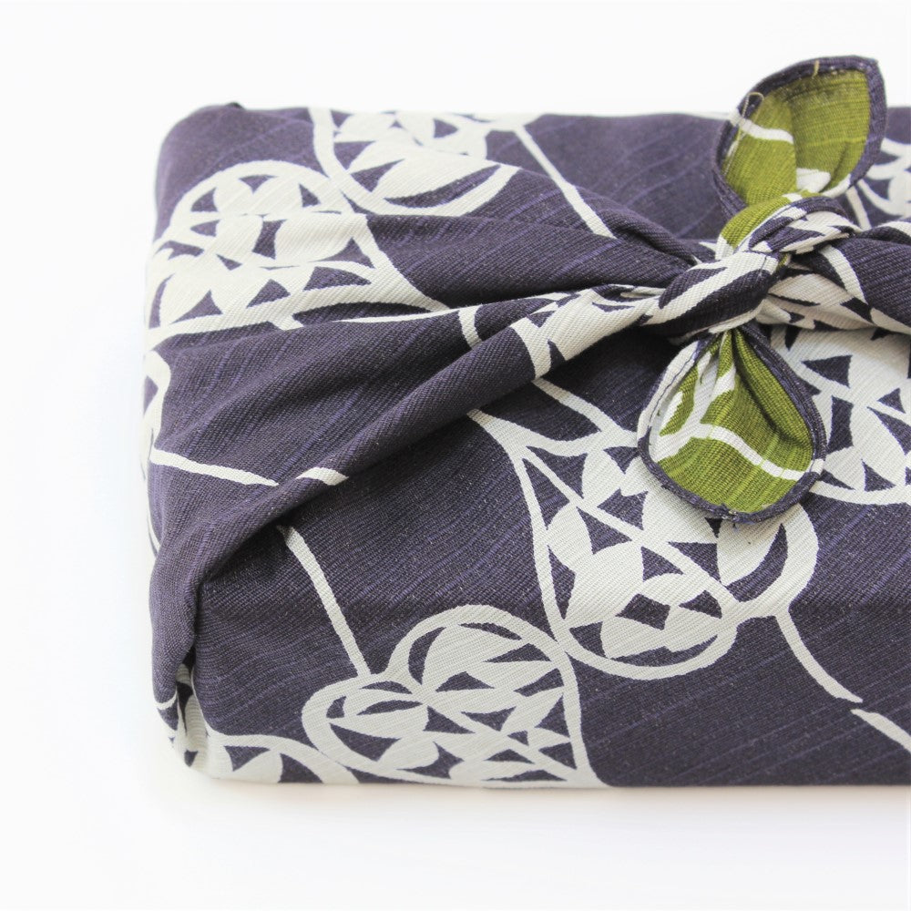 This reversible furoshiki from Majime Life has a green and purple background. This image shows the purple side. 