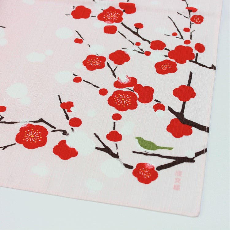 CLose up shot showing the red Japanese plum flowers on this furoshiki