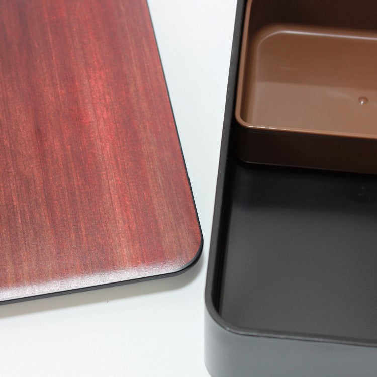 Close up shot showing the woodgrain tone of the lid, and the insides of the bento box