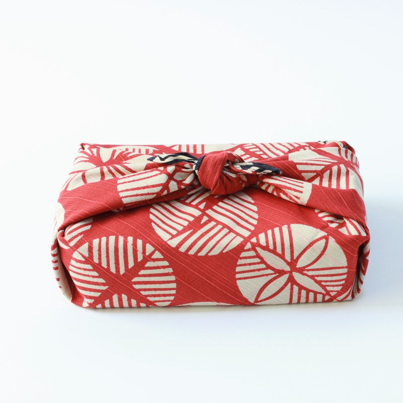 Side view of bento box wrapped with the isa monyo pine pattern furoshiki japanese wrapping cloth, red side
