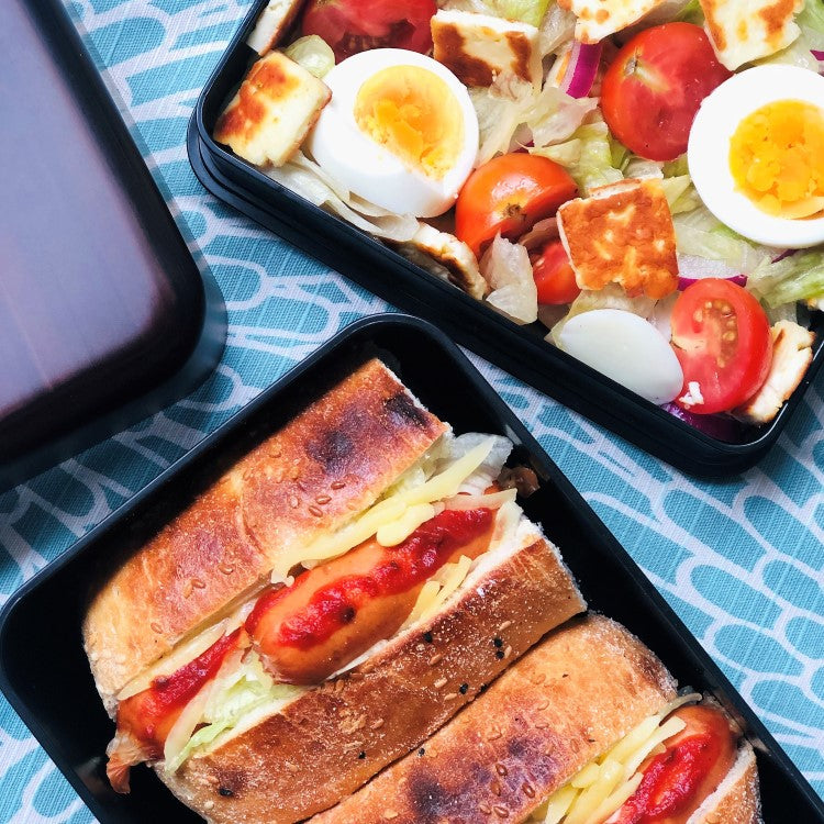 Overhead show showing hot dog and salad inside benkei big bento box