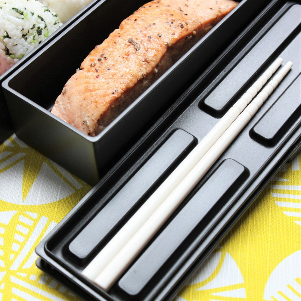 A small pair of chopstics can be stored on the inner lid