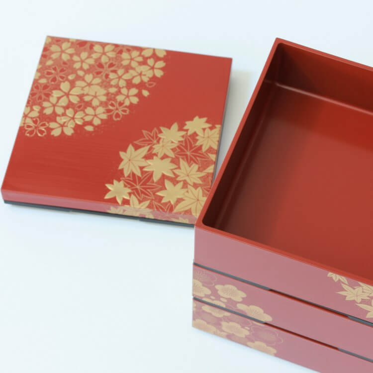 lid laid next to stacked vermillion picnic bento box