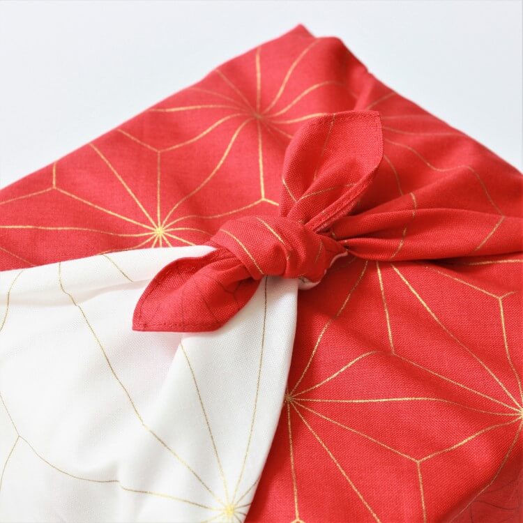 close up of tied knot of hare tsutumi asanoha red furoshiki
