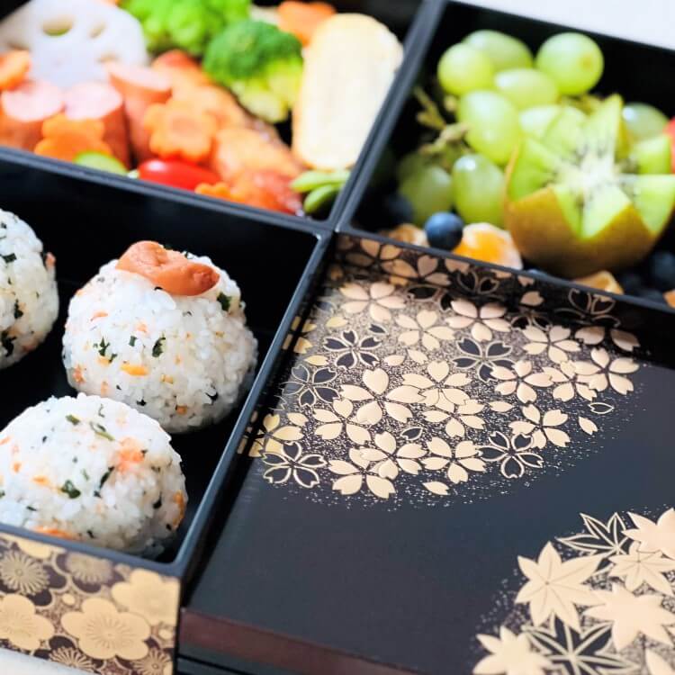 close up shot showing food in the compartments of the hanamaru brown 3 tier bento box