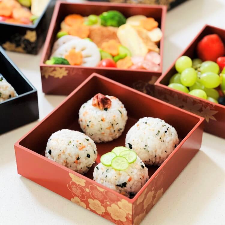 close up shot of riceballs in one layer of the 3 tier bento box