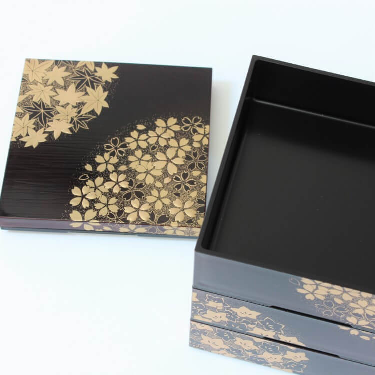 overhead shot showing lid and opened top layer of a 3 tier picnic bento box