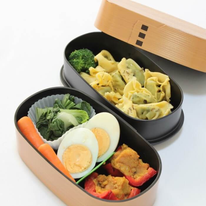 Wood tone wappa style japanese bento box with food inside