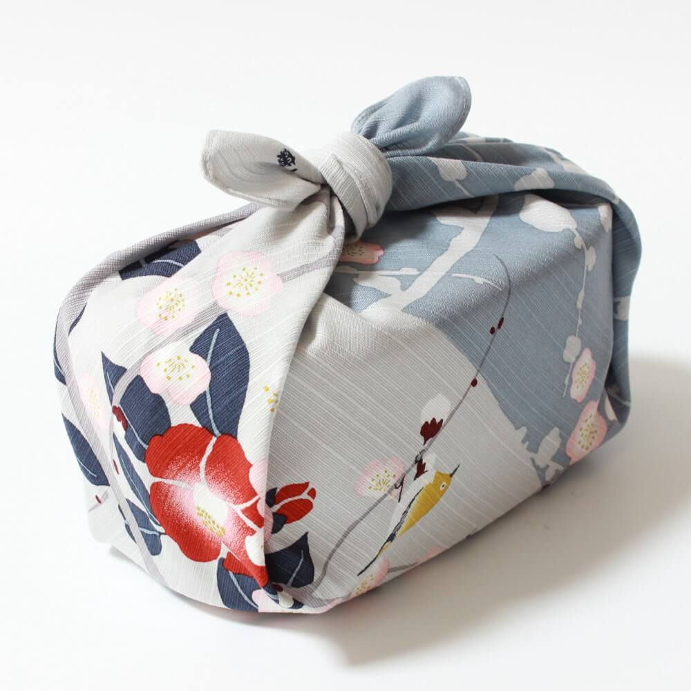 angled bento box shot wrapped in grey furoshiki of plum and camellia flowers