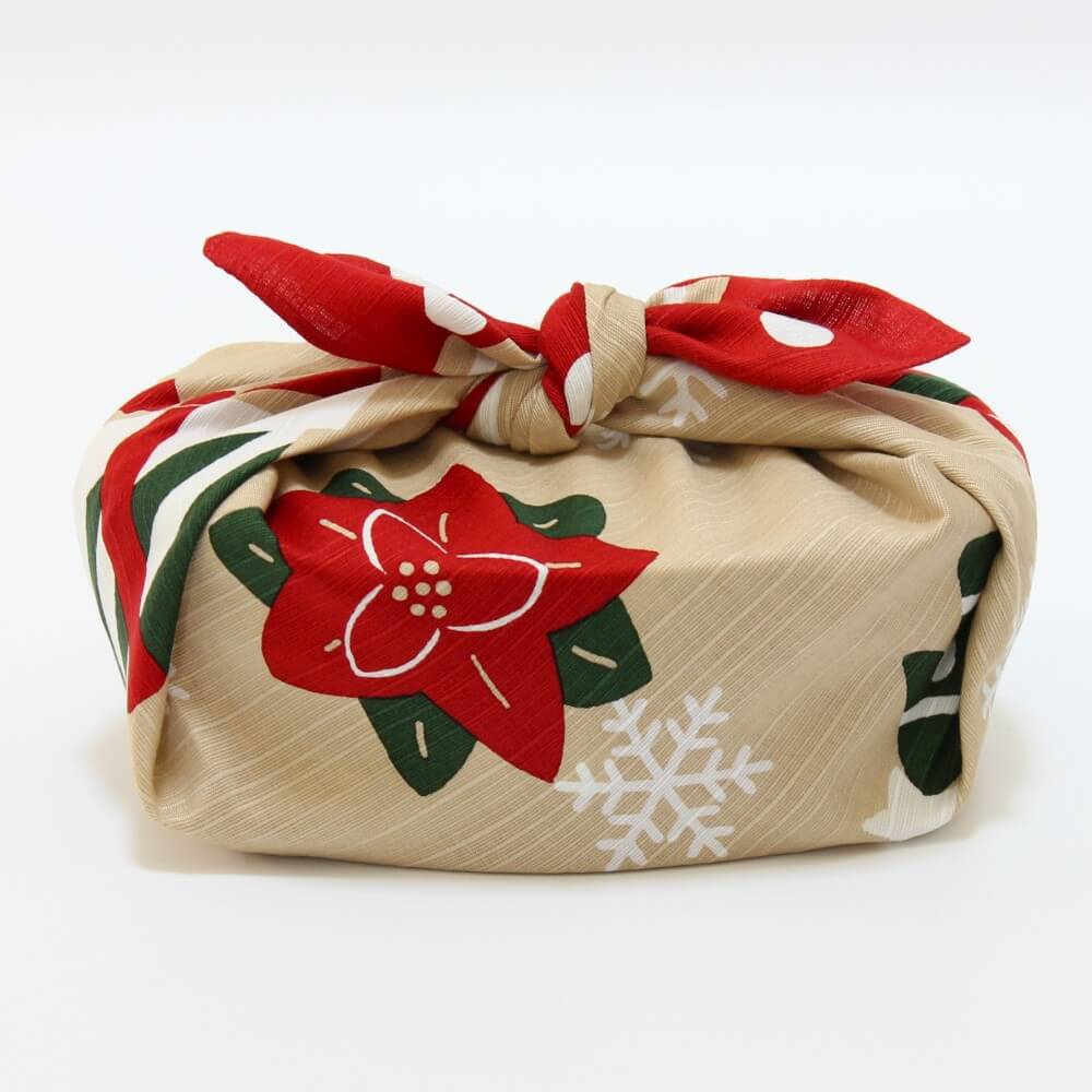 bento box wrapped in christmas furoshiki with poinsettia flower in the front