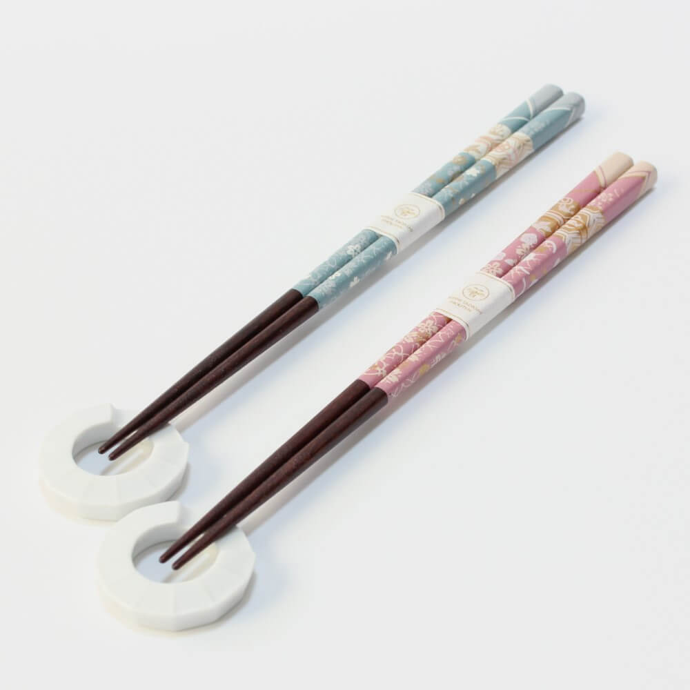 blue and pink chopsticks resting on their separate chopsticks rests
