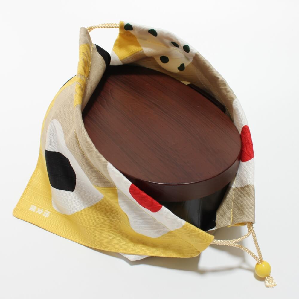 brown bento box inside yellow bento lunch bag