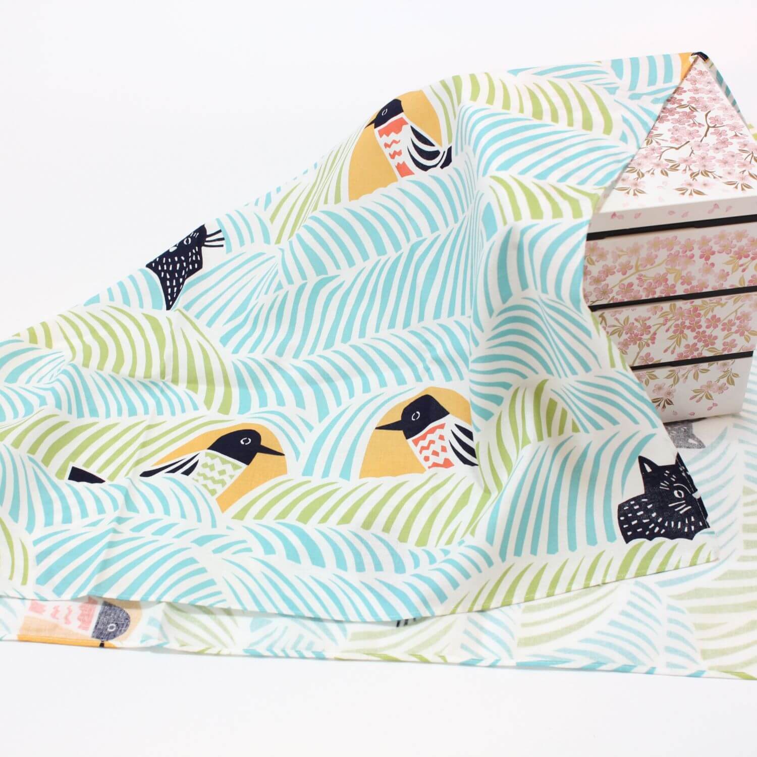 cat and bird furoshiki covering a sakura themed white jubako