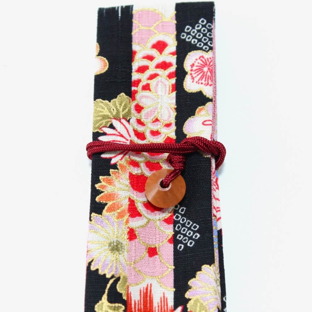 close up of abacus bead with string on black fabric chopsticks case