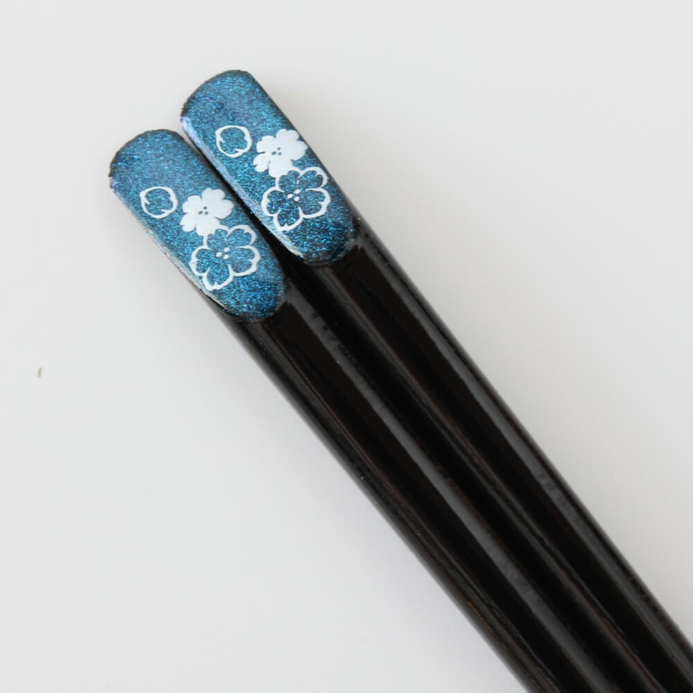 close up black tensoge chopsticks with cosmos patterns on blue glittering tensoge top
