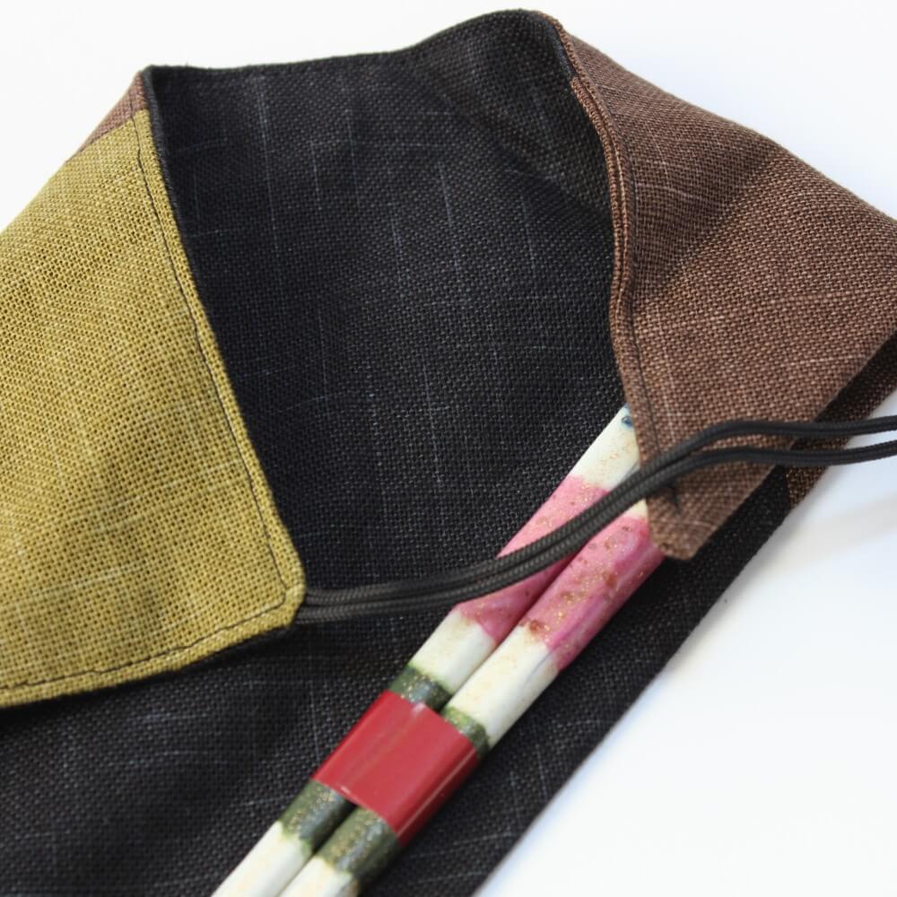 close up of chopsticks handles inside wafu green fabric case