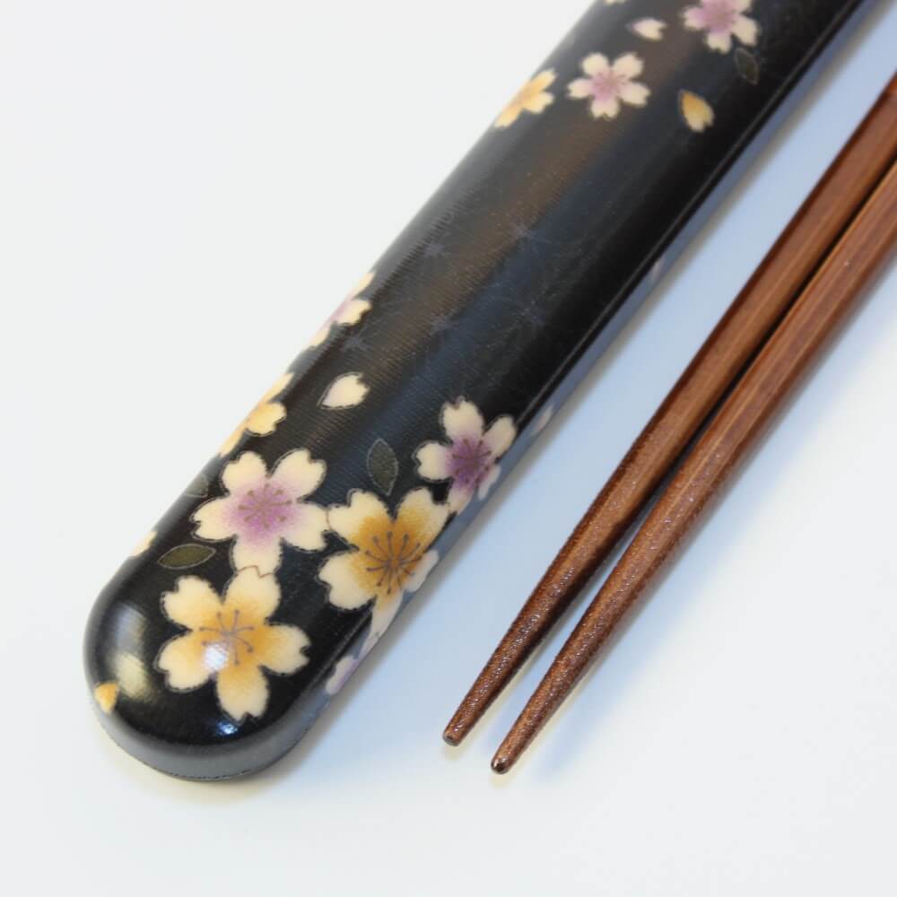 close up chopsticks tips and sakura flowers black case