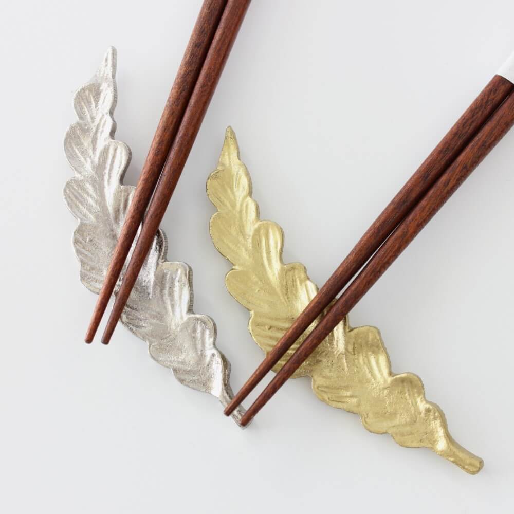 close up chopsticks tips on leaf shaped rests