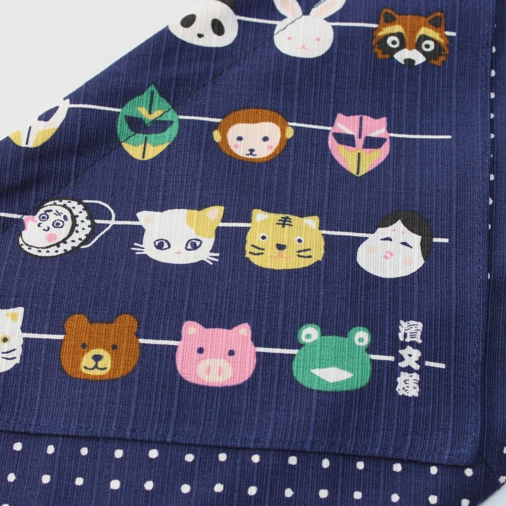 close up of japanese masks on navy kinchaku bento bag